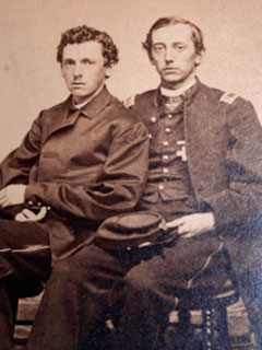 Two men in military uniforms sitting next to each other.