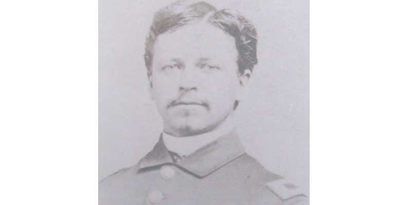 A man in uniform is shown with a mustache.