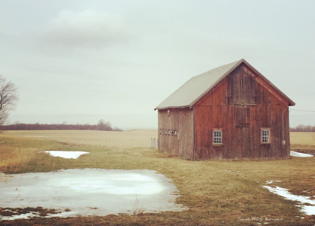 A barn sitting in the middle of a field.