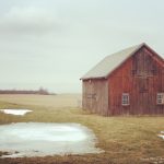 A barn sitting in the middle of a field.