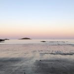 A beach with water and sand on it