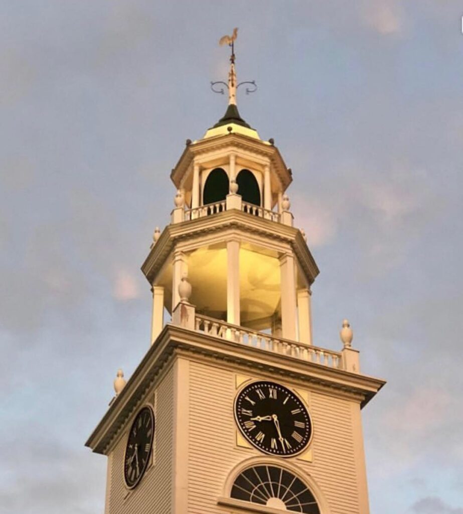 A clock tower with two clocks on each side of it.