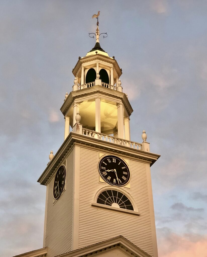 A clock tower with two clocks on each side of it.