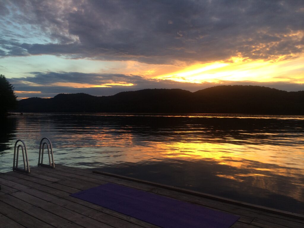 A body of water with a sunset in the background.