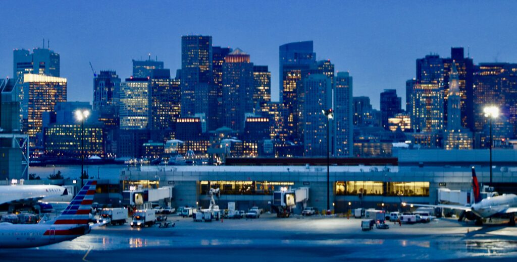 A city skyline with buildings lit up at night.